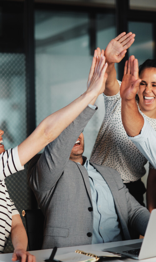 Businesspeople high-fiving at work