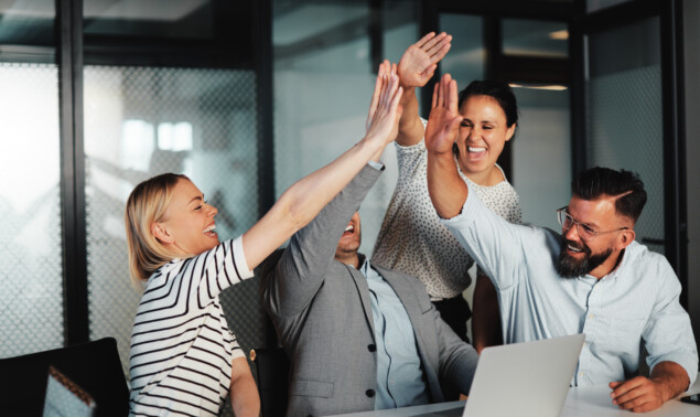 Businesspeople high-fiving at work