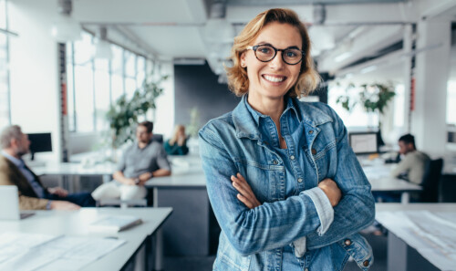 Happy female designer standing in office